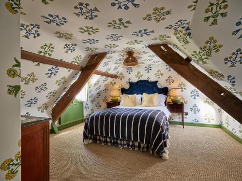 马姆斯伯里Townhouse Suites- Abbey Row的一间卧室配有一张蓝色花卉壁纸床
