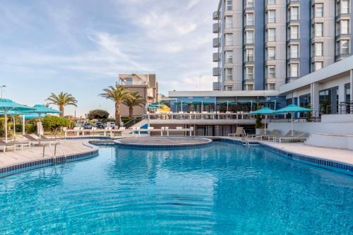 索托马里纳B&B Hotel Chioggia Airone的大楼前方的大型蓝色海水游泳池