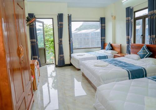吉婆岛Long Thành Motel的一间卧室设有三张床和大窗户
