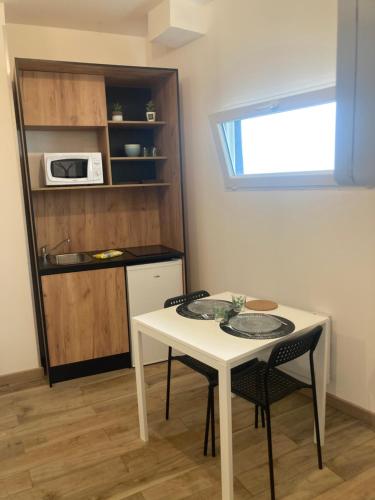 GaillonLe mini cosy的小厨房配有白色的桌子和两把椅子