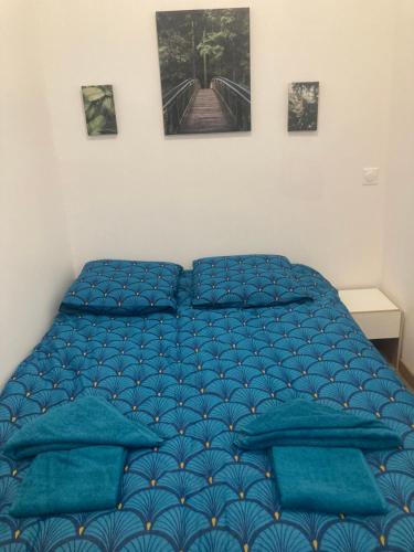 GaillonLe mini cosy的一间卧室配有蓝色的床和蓝色枕头
