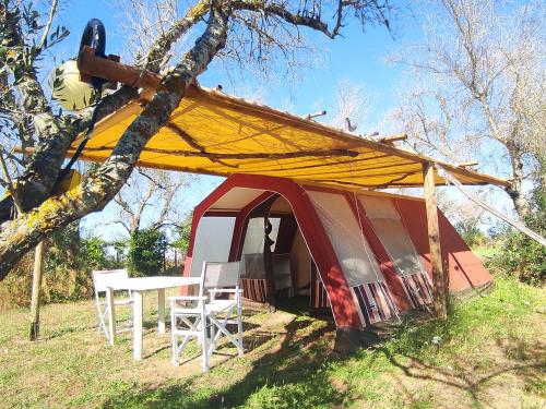 库特罗菲安诺Camping Terreno-Ro-Bi-Li的红色和白色的帐篷,配有桌椅