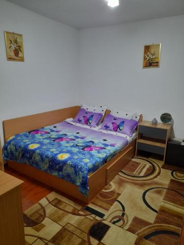 克利默内什蒂Casuta Maria Alexandra的一间卧室配有一张床、一张桌子和一张地毯。