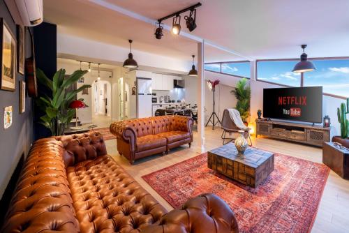 伊斯坦布尔Monnas Suite的客厅配有大型真皮沙发和电视