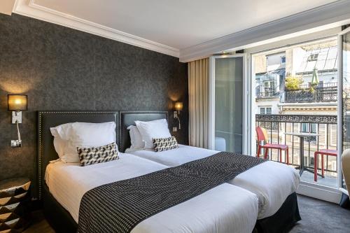 巴黎迪瓦歌剧院酒店的一间卧室设有一张大床和一个阳台