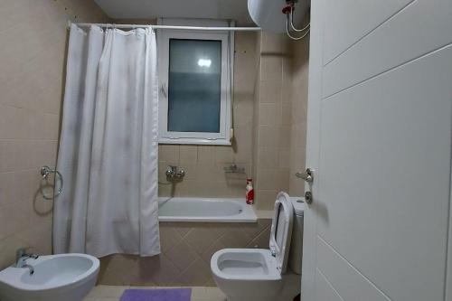 地拉那Tranquil Oasis for Two的浴室配有卫生间、浴缸和水槽。