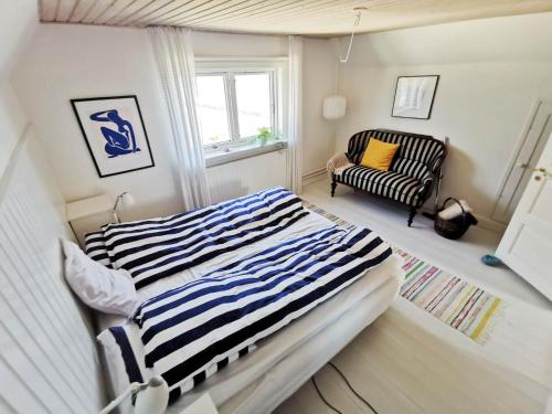HylleholtSeaview的卧室配有条纹床和椅子