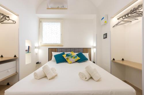 加利波利Coral - 30 passi dalla Spiaggia della Purità的白色卧室配有白色大床和蓝色枕头