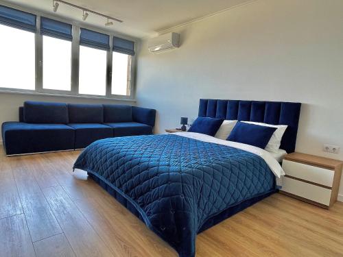 切尔卡瑟1-к квартира люкс з видом на Дніпро的一间卧室配有蓝色的床和沙发