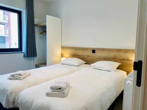 米德尔克尔克Belcasa Mar Suites & Lofts的一间卧室配有两张带毛巾的床