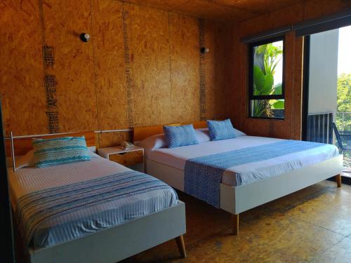 图斯特拉古铁雷斯Hotel Momotus的一间卧室设有两张床和窗户。