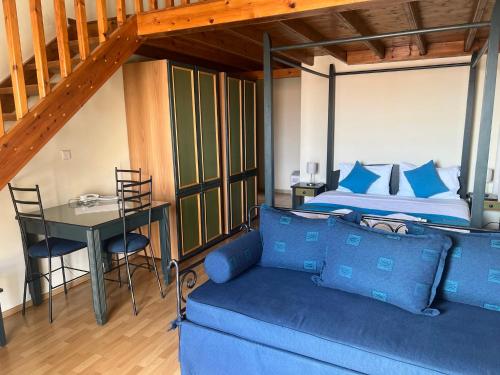 尼基季Studio Nikiti Beach的客厅配有蓝色的沙发和床。