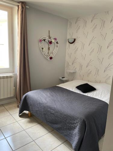 ManthesCafé du lac的卧室配有一张床,墙上有心花圈