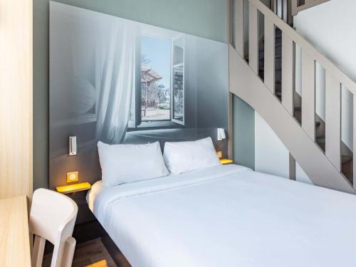 雷恩B&B HOTEL Rennes Sud Chantepie的一间卧室配有一张床和一个楼梯间