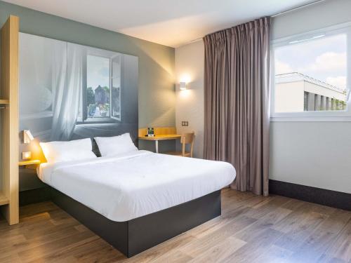 雷恩B&B HOTEL Rennes Ouest Villejean的一间设有大床和窗户的酒店客房
