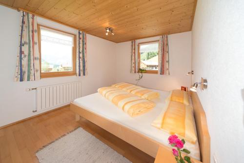 施科佩尔瑙Appartement Elisabeth的卧室设有一张白色大床和两个窗户。