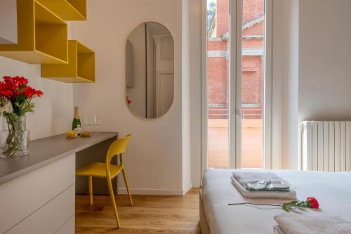 米兰BnButler - Sebenico, 28 - Nuovissimo Appartamento in Isola的一间卧室配有一张床、一张桌子和一面镜子