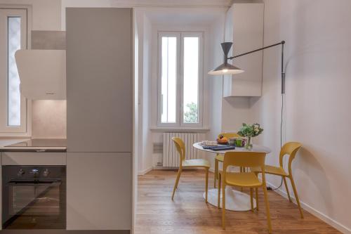 米兰BnButler - Sebenico, 28 - Nuovissimo Appartamento in Isola的厨房配有桌椅和窗户。