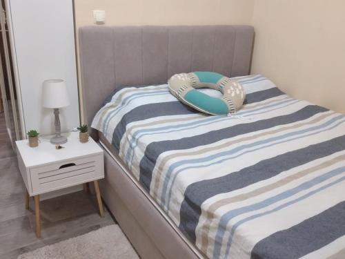 扎达尔Zadar charming studio的一张带蓝色和白色条纹床单的床和玩具