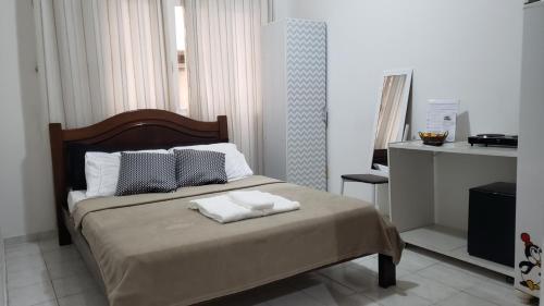 尼泰罗伊Loft Aconchegante Centro Niterói / RJ Inter 300Mb的一间卧室配有一张床,上面有两条毛巾