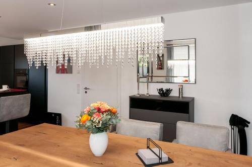 若特阿赫-埃根Ferienwohnung RottachSuite的用餐室,配有花瓶桌子