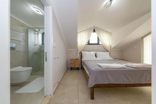 费特希耶Villa Lina Ölüdeniz/Fethiye的一间卧室配有一张床、淋浴和浴缸