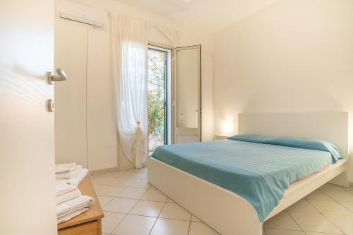兰佩杜萨Villetta Bianca的白色的卧室设有床和窗户