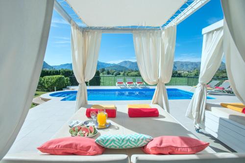 波连斯萨Owl Booking Villa Siquier - Luxury Retreat with Mountain Views的带一张桌子和游泳池的床的房间
