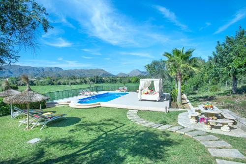 波连斯萨Owl Booking Villa Siquier - Luxury Retreat with Mountain Views的后院设有游泳池和草坪