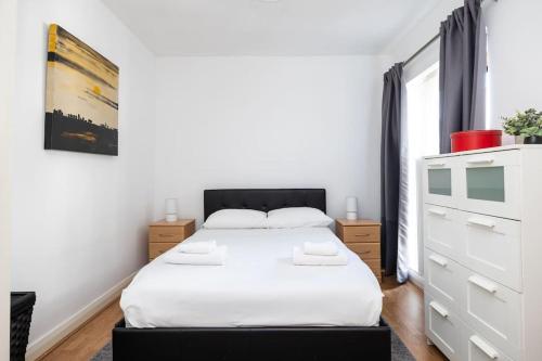 都柏林Peaceful 1 bedroom apartment in Portobello, Dublin的一间白色卧室,配有一张床和一个梳妆台