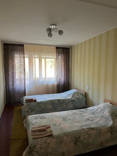 纳尔瓦约埃苏Apartment on Karja的酒店客房设有三张床和窗户。
