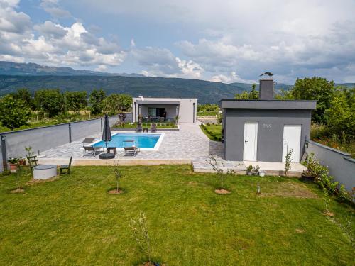 莫斯塔尔Villa Vukas的一个带游泳池和房子的后院