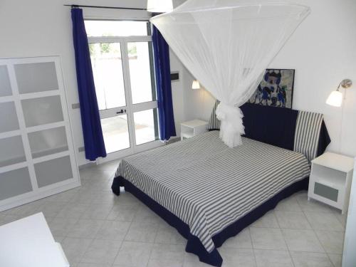 托里德欧索villa Annarè的一间卧室配有一张带天蓬和窗户的床