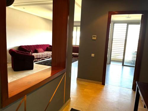 诺阿瑟Short Stay Apartment aéroport casablanca的客厅配有红色的沙发和镜子