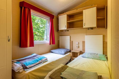 加斯泰Mobilehome Bernard的小型客房 - 带2张床和窗户
