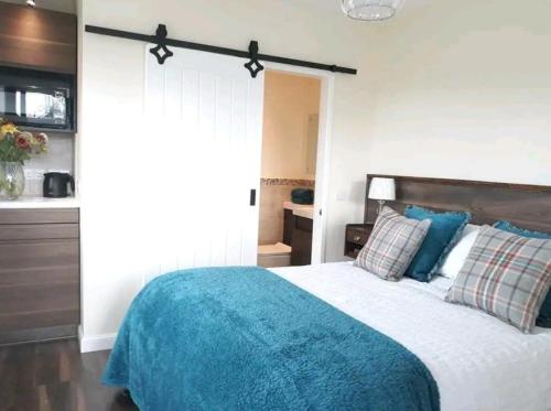 Middleton FossowayThe Wee Stay - Room Only - Rural 1 Bed Guest Suite的一间卧室配有一张带蓝色毯子的床