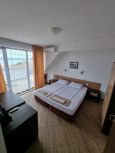 普里莫尔斯科Стаи за гости Мистрал的一间卧室设有一张床和一个大窗户