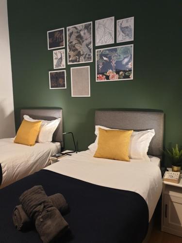 伯明翰Platinum Apartment Birmingham- Free Secure Parking- Fast Fibre Wi-Fi的墙上有两张照片的房间的床铺