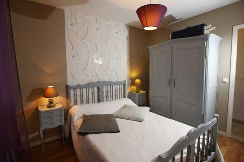Benesse-lez DaxCabernet的卧室配有白色的床、橱柜和灯具。