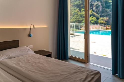 加尔达湖滨GARNI' FOCI的一间卧室配有一张床,享有游泳池的景色