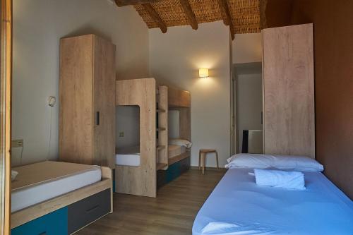BotLo Molí de Bot的一间卧室设有两张床和木制橱柜。