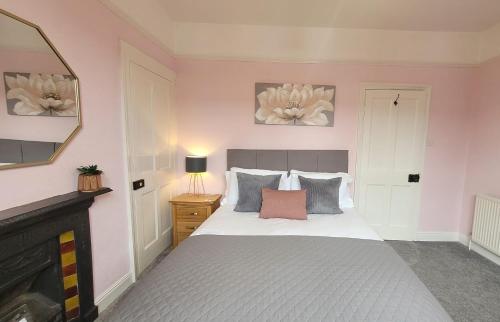 约克Hartoft St - 2 bed near river的一间卧室配有白色床单和粉红色墙壁。