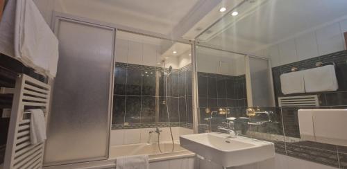 采尔马特La Perle Apartments的白色的浴室设有水槽和淋浴。