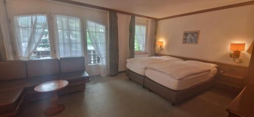 采尔马特La Perle Apartments的卧室配有一张床、一张书桌和窗户。
