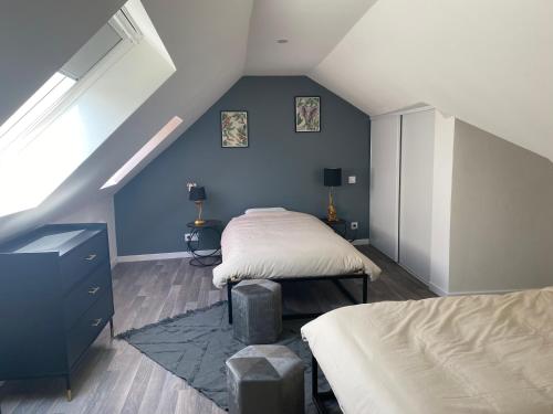 Saint-Aignan*La Stracciatella / Saint-Aignan的阁楼卧室设有两张床和蓝色的墙壁