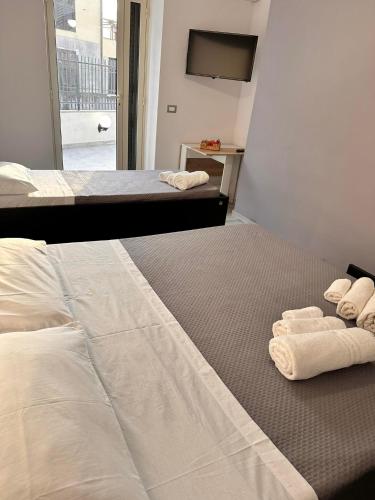 卡塔尼亚Airport Al Volo B&B的酒店客房的地板上配有两张带毛巾的床。