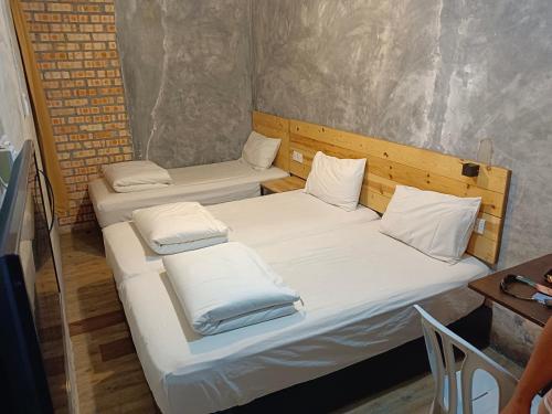 万津麦尔斯酒店的小型客房配有两张单人床和一张桌子。