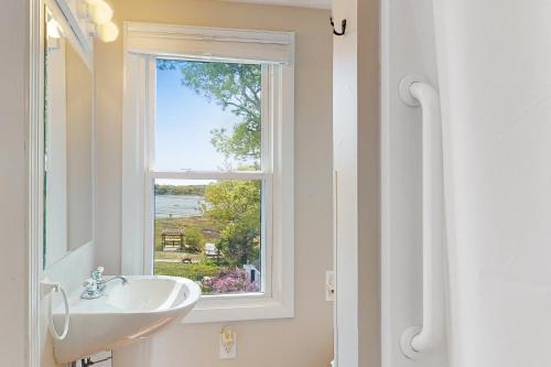 瓦尔汉Sunset Cove Retreat的一间带水槽和窗户的浴室