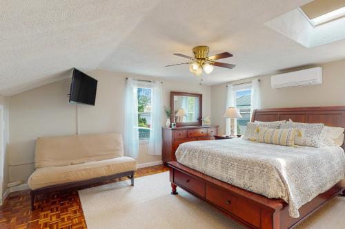 瓦尔汉Sunset Cove Retreat的一间卧室配有一张床和吊扇