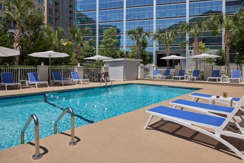 查尔斯顿Holiday Inn Express & Suites Charleston DWTN -Westedge, an IHG Hotel的一座带躺椅的游泳池和一座建筑